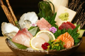 Omakase sashimi plate featuring fresh hamachi (yellowtail) slices served with wasabi and garnishes
